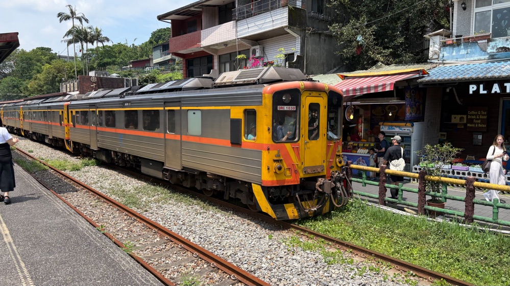 十分の線路沿いの商店街を走る平渓線の電車