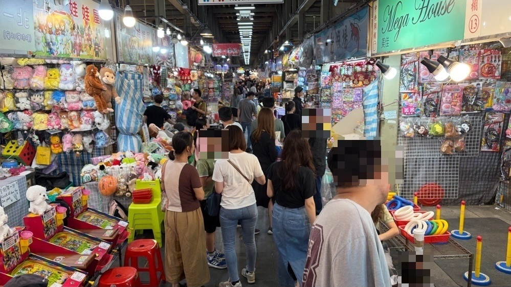 士林夜市の通路。両側に雑貨やゲームの店が並び、人で混み合っている