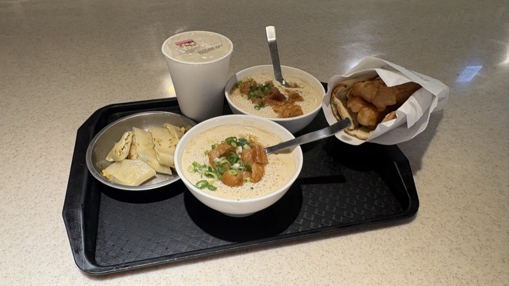 阜杭豆漿のトレー。鹹豆漿2杯、豆漿のカップ、卵入りの薄餅、油條入りの厚餅が並んでいる