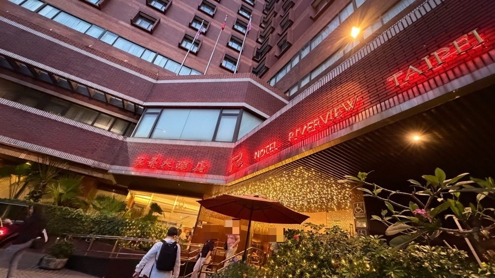 夕方のホテル リバービュー(豪景大酒店)の入口。HOTEL RIVERVIEW TAIPEIのネオンが光る