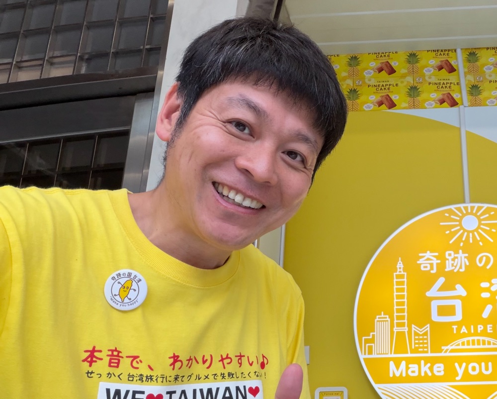 奇跡の国 台湾の店内。黄色いTシャツを着たお店の方と、店のロゴが入った看板