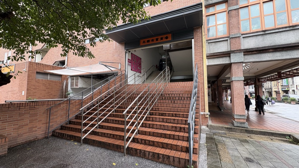 永樂布業商場の入口。赤レンガの階段の上に永樂布業商場の看板がある