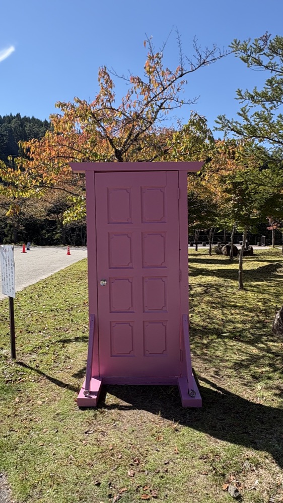 道の駅桜の郷荘川の芝生に立っているピンク色のどこでもドアの展示